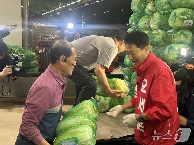 오세훈 국민의힘 서울시장 후보가 공식 선거운동이 시작되는 21일 가락동 농수산물 도매시장을 찾아 배추를 나르고 있다.뉴스1 구진욱 기자