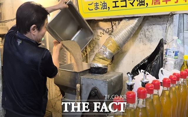 19일 낮 서울 중구 중부 건어물 시장 '충북제유소' 대표 최성환 씨가 일본어로 적힌 안내 표지판 아래 기계에서 기름을 내리고 있다. /서울 중구=오승혁 기자