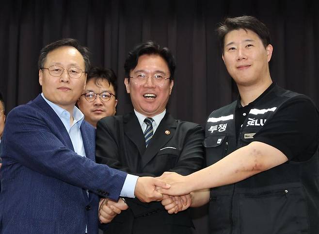 20일 경기 수원시 장안구 경기고용노동청에서 열린 삼성전자 임금협상을 마친 후 여명구 삼성전자 DS(디바이스솔루션·반도체 사업 담당) 피플팀장(왼쪽부터)과 김영훈 고용노동부 장관, 최승호 삼성그룹 초기업노동조합 삼성전자지부 위원장이 잠정 합의한에 서명한 후 손을 맞잡고 있다. 2026.5.20 /사진=뉴스1