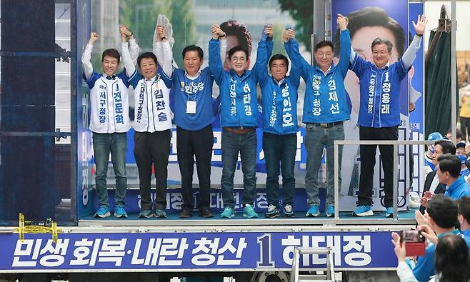 정청래(왼쪽 세 번째) 더불어민주당 대표(총괄상임선거대책위원장)가 공식 선거운동 첫날인 21일 대전 중구 으능정이 문화의거리에서 열린 민주당 출정식에서 허태정(네 번째) 대전시장 후보와 5개 자치구청장 후보들과 함께 손을 잡고 지지를 호소하며 승리를 다짐하고 있다. 연합뉴스