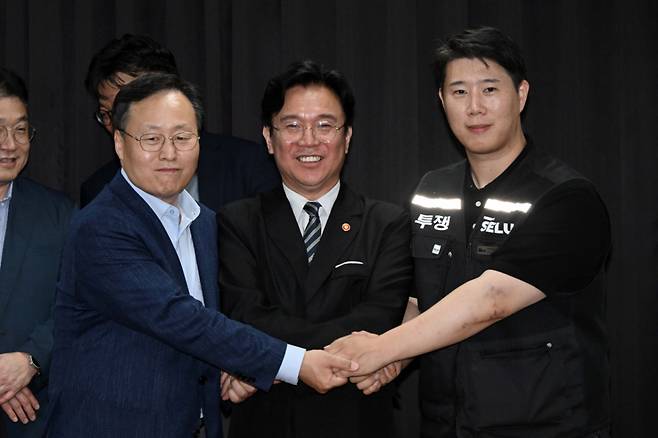 [수원=뉴시스] 김종택기자 = 삼성전자 노사 협상이 잠정 합의된 20일 경기도 수원시 장안구 경기지방고용노동청에서 김영훈 고용노동부 장관, 최승호 삼성전자 노조 공동투쟁본부 위원장, 여명구 DS(디바이스솔루션·반도체 사업 담당) 피플팀장이 손을 맞잡고 있다. 이날 삼성전자 노사는 김영훈 고용노동부 장관의 중재로 다시 임금협상에 나섰다. (공동취재) 2026.05.20. photo@newsis.com /사진=김종택