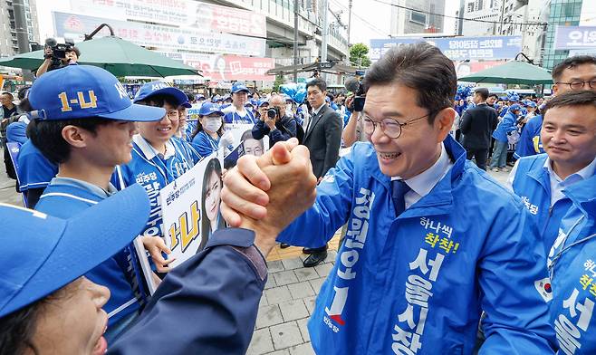 더불어민주당 정원오 서울시장 후보가 21일 서울 광진구 자양사거리에서 열린 거리 유세를 마친 뒤 선거운동원들과 인사를 나누고 있다.