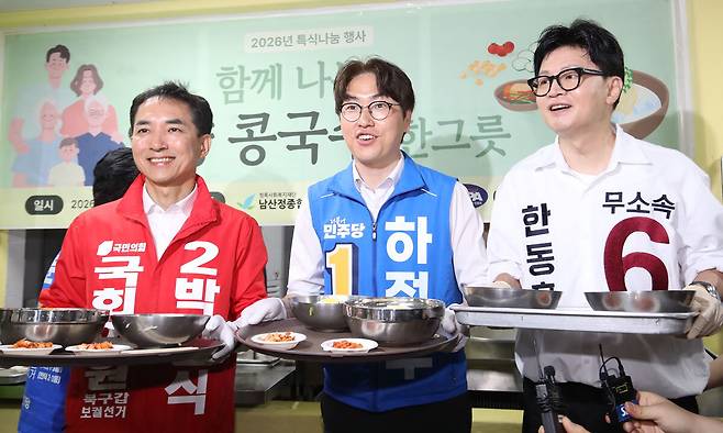 거리두고 선 보수 후보들 부산 북구갑 국회의원 보궐선거에 출마한 후보들이 21일 부산 북구 남산정종합사회복지관에서 노인들에게 콩국수 배식을 하기 위해 식판을 들고 있다. 왼쪽부터 국민의힘 박민식 후보, 더불어민주당 하정우 후보, 무소속 한동훈 후보. 부산=뉴스1