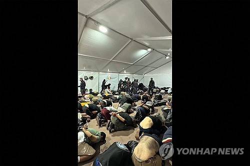 이스라엘군 임시 수용소에서 두 손이 묶인 채 무릎을 꿇고 있는 구호선단 활동가들 [AFP 연합뉴스. 재판매 및 DB 금지]