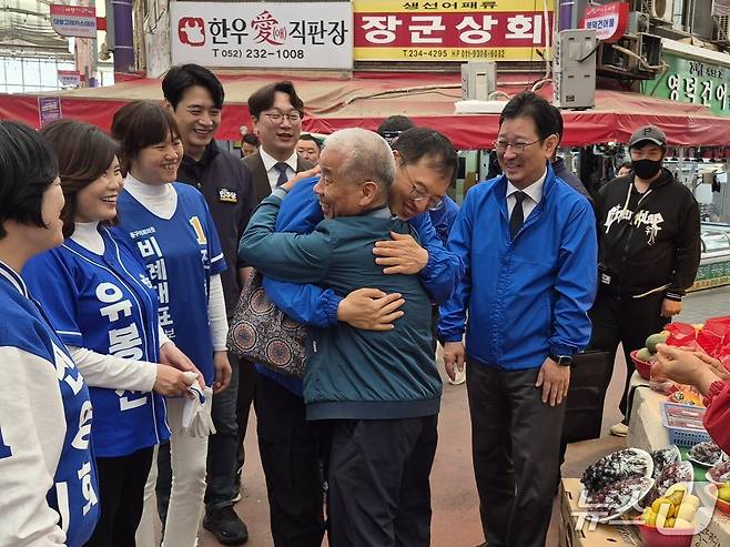 김상욱 더불어민주당 울산시장 후보가 22일 오전 동구 대송시장에서 같은 당 한준호·모경종·김태선 의원과 유세를 하면서 시민과 포옹하고 있다.(민주당 울산시당 제공. 재판매 및 DB금지)/뉴스1