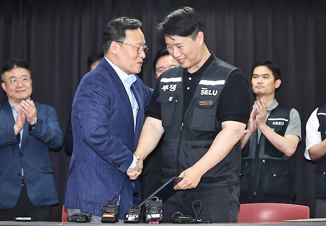 20일 경기 수원시 소재 경기고용노동청에서 열린 삼성전자 노사 교섭대표위원들이 임금 협상 잠정 합의안에 서명한 뒤 손을 맞잡고 있다. 공동취재단
