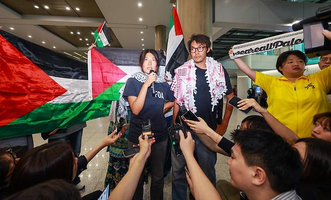 이스라엘군에 나포됐던 활동가 김아현(왼쪽)씨와 김동현씨가 22일 인천국제공항 1터미널을 통해 귀국한 뒤 취재진 질문에 답하고 있다. 뉴스1