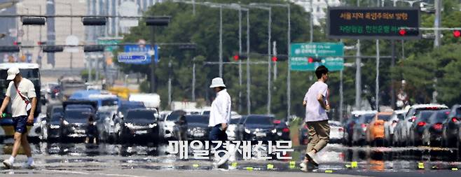 무더위가 만든 아지랑이가 핀 아스팔트 위로 시민들이 걸어가고 있다. [김호영 기자]