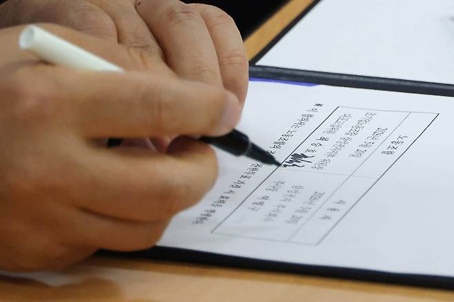 여명구 삼성전자 DS(디바이스솔루션·반도체 사업 담당) 피플팀장이 20일 오후 경기 수원시 장안구 경기지방고용노동청에서 열린 삼성전자 노사교섭 결과 브리핑에서 합의안에 서명을 하고 있다. /사진=뉴스1(공동취재)