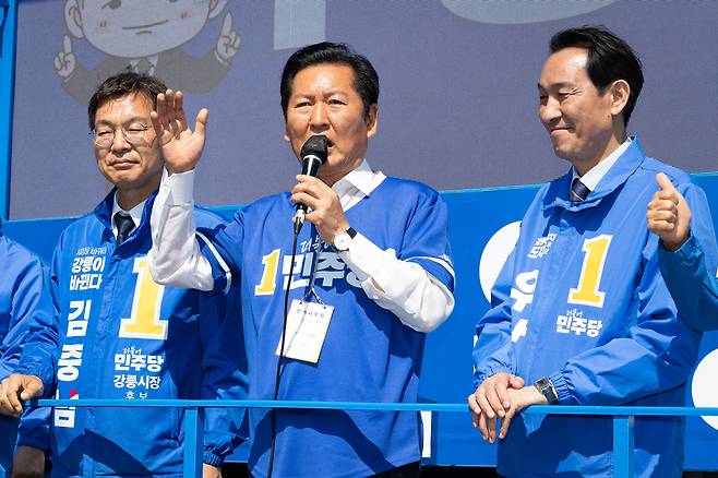 우상호 강원특별자치도지사 후보와 김중남 강릉시장 후보 지원유세에 나선 정청래 더불어민주당 대표가 22일 강원 강릉시 주문진 시장 앞에서 시민들을 향해 지지를 호소하고 있다. /뉴스1