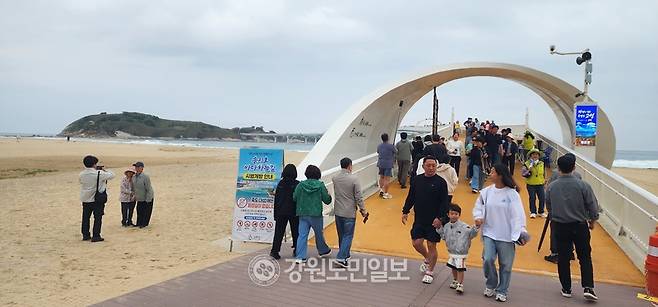 ▲ 동해안 홍해 송지호 대섬 바다하늘길이 23일 시범 운영 첫날을 맞아 인산인해를 이루며 글로벌 해양관광명소로의 도약을 예고했다. 입장하는 인파들. 김주현 기자