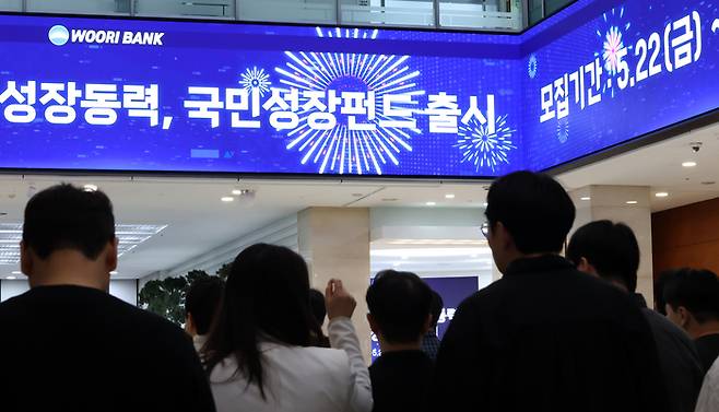 지난 21일 서울 중구 우리은행 본점 로비 스크린에 국민성장펀드 안내문이 나오는 모습. [연합뉴스]