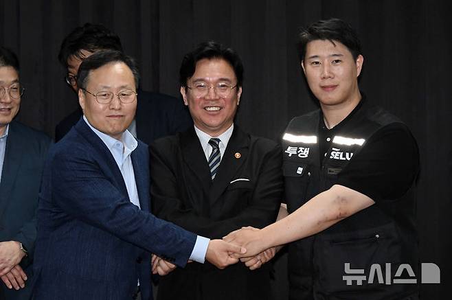 [수원=뉴시스] 김종택기자 = 삼성전자 노사 협상이 잠정 합의된 20일 경기도 수원시 장안구 경기지방고용노동청에서 김영훈 고용노동부 장관, 최승호 삼성전자 노조 공동투쟁본부 위원장, 여명구 DS(디바이스솔루션·반도체 사업 담당) 피플팀장이 손을 맞잡고 있다. 이날 삼성전자 노사는 김영훈 고용노동부 장관의 중재로 다시 임금협상에 나섰다. (공동취재) 2026.05.20. photo@newsis.com