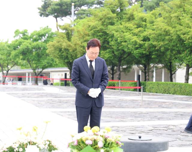 23일 오전 일찍 봉하마을 간 박완수 후보가 고 노무현 대통령 묘소에 헌화한 뒤 묵념하고 있다. 국민의힘 제공
