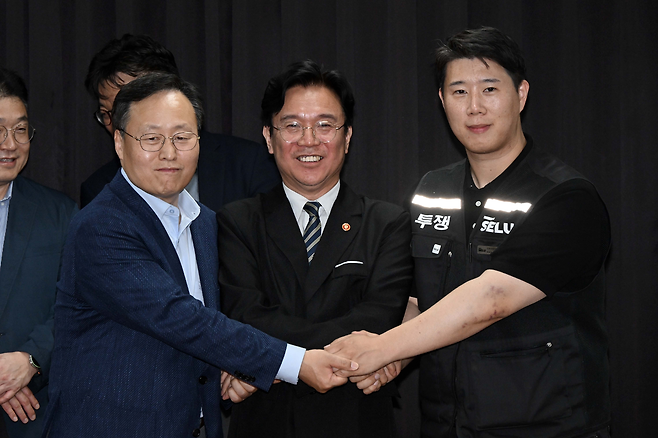 20일 경기도 수원시 장안구 경기고용노동청에서 열린 삼성전자 임금협상을 마친 후 여명구 삼성전자 DS(디바이스솔루션·반도체 사업 담당) 피플팀장과 김영훈 고용노동부 장관, 최승호 삼성그룹 초기업노동조합 삼성전자지부 위원장이 잠정 합의한에 서명한 후 손을 맞잡고 있다. 뉴스1