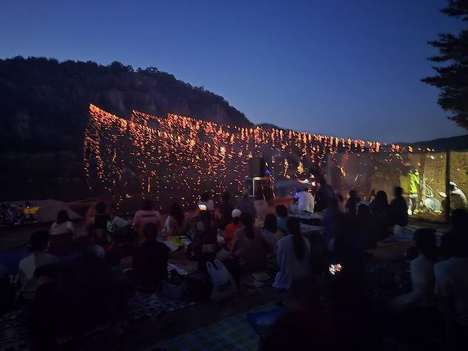 23일 밤 안동 하회마을 만송정 숲 일대에서 선유줄불놀이가 펼쳐지자 관광객들이 낙동강 위로 흩날리는 불꽃을 바라보며 공연을 관람하고 있다. /이도훈 기자