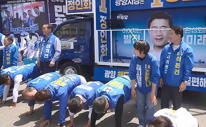 지난 24일 옥곡5일장에서 진행된 민주당 선거유세 도중 한 지지자가 얼차려를 지시하자 일부 후보들이 엎드리고 있다.유튜브 델리민주 갈무리