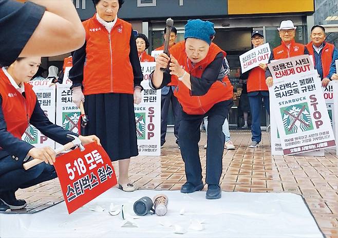 스타벅스 텀블러·머그컵 부수는 시민단체  23일 광주 서구 광천동 이마트 앞에서 옛 전남도청 복원지킴이 회원들이 스타벅스 텀블러와 컵을 망치로 부수고 있다. 스타벅스가 5·18 탱크데이 이벤트에서 박종철 고문치사 사건을 폄훼했다는 비판이 일면서 관공서와 시민 단체 등의 불매 운동이 심화하고 있다. /연합뉴스