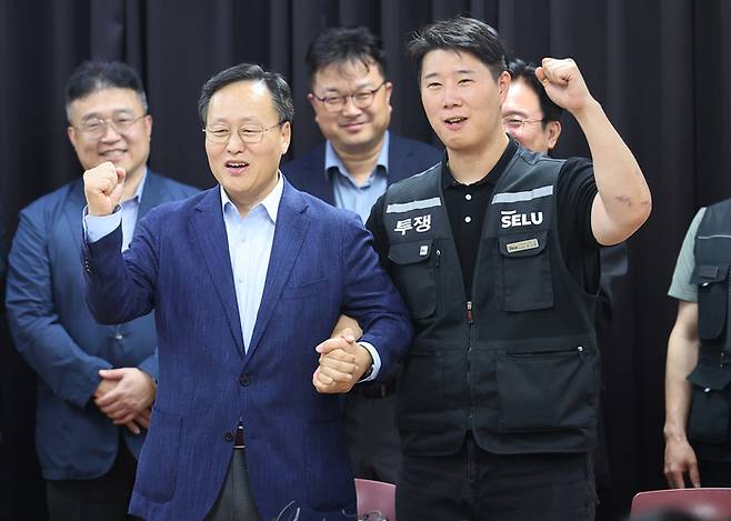 지난 20일 경기도 수원시 장안구 경기고용노동청에서 열린 삼성전자 임금협상을 마친 후 여명구 삼성전자 DS(디바이스솔루션·반도체 사업 담당) 피플팀장과 최승호 삼성그룹 초기업노동조합 삼성전자지부 위원장이 잠정 합의안에 서명한 후 파이팅을 외치고 있다. [연합뉴스]