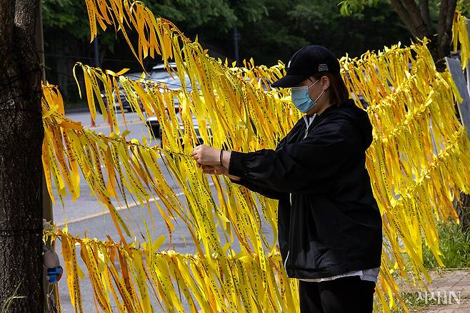 5월11일 오전 광주 광산구 여고생 살인사건 현장에 마련된 추모공간을 찾은 한 시민이 추모글을 쓴 리본을 달고 있다. ⓒ시사IN 조남진