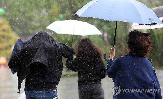 서울 광화문광장 부근에서 시민들이 우산을 쓰고 이동하는 모습 [연합뉴스 자료사진]