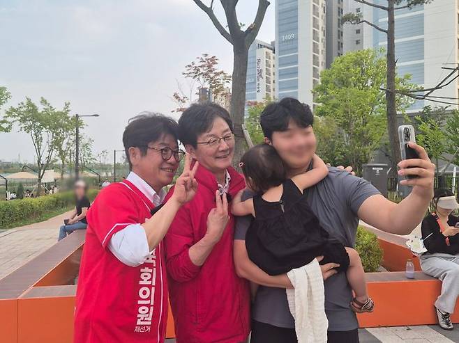 유의동 국민의힘 후보와 유승민 전 의원이 25일 오후 평택시 고덕동 함박산 중앙공원에서 만난 한 시민과 사진 촬영을 하고 있다.ⓒ데일리안 허찬영 기자