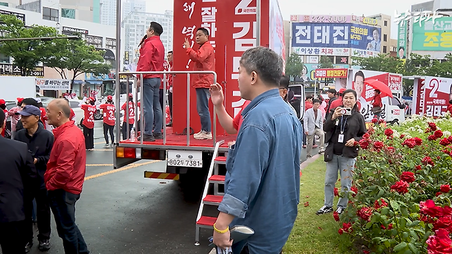 ▲뉴스타파 김성수 기자(가운데 파란색 셔츠)가 지난 21일 선거운동차량 주변에서 김두겸 울산시장 후보의 유세가 끝나길 기다리고 있다.