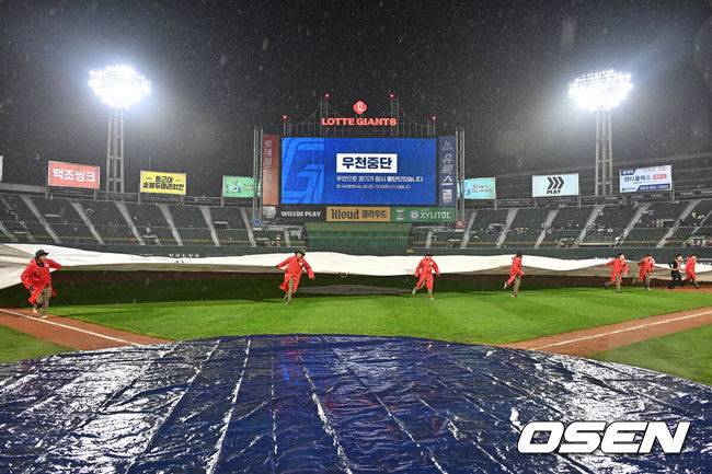 [OSEN=부산, 이석우 기자] 26일 부산 사직야구장에서 2026 신한 SOL KBO 리그 롯데 자이언츠와 LG 트윈스의 경기가 열렸다. 홈팀 롯데는 비슬리가, 방문팀 LG는 톨허스트가 선발 출전했다.관계자들이 많은 비가 내려 우천 중단된 경기장에 방수포를 덮고 있다. 2026.05.26 / foto0307@osen.co.kr