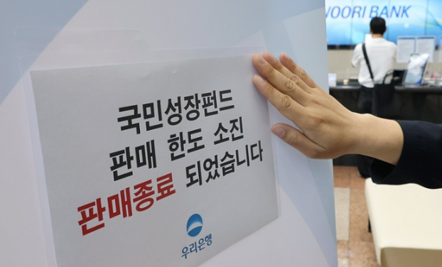 국민참여성장펀드 가입 첫날인 22일 서울 중구 우리은행 본점 영업점에서 한 직원이 한도소진으로 인한 판매종료 안내문을 붙이고 있다.연합뉴스