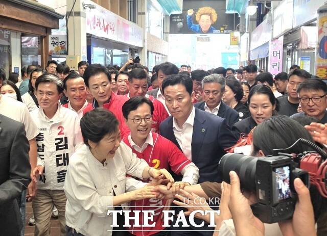 박근혜 전 대통령과 윤용근 국민의힘 후보(가운데)가 25일 공주산성시장에서 유권자들에게 지지를 호소하고 있다. /김형중 기자