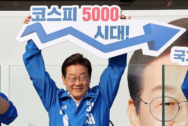 지난해 5월 29일 당시 더불어민주당 대선후보였던 이재명 대통령이 서울 서초구 서울고속버스터미널광장에서 열린 유세에서 '코스피 5000 시대' 팻말을 들고 경제회복 퍼포먼스를 하고 있다(자료사진). ⓒ뉴시스