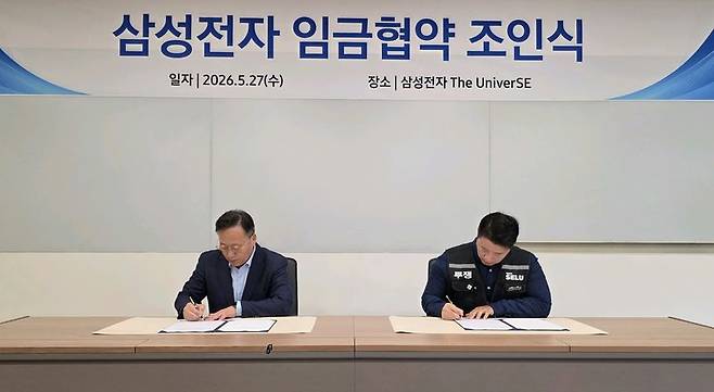 여명구 삼성전자 부사장(사진 왼쪽)과 최승호 삼성그룹 초기업노동조합 삼성전자 지부 위원장이 27일 경기 용인시 기흥 삼성전자 The UniverSE에서 2026년 임금협약을 체결하고 있다. 삼성전자 제공