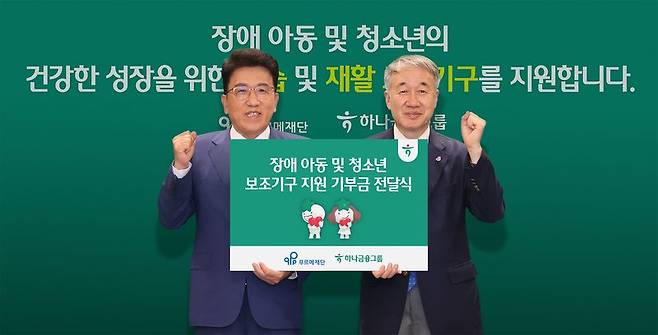 함영주 하나금융그룹 회장(왼쪽)과 백경학 푸르메재단 상임대표가 지난 26일 열린 서울 명동 하나금융 사옥에서 장애 아동·청소년을 위한 재활 및 학습 보조기구 지원사업 기부금 전달식에서 기념촬영을 하고 있다. 하나금융지주 제공