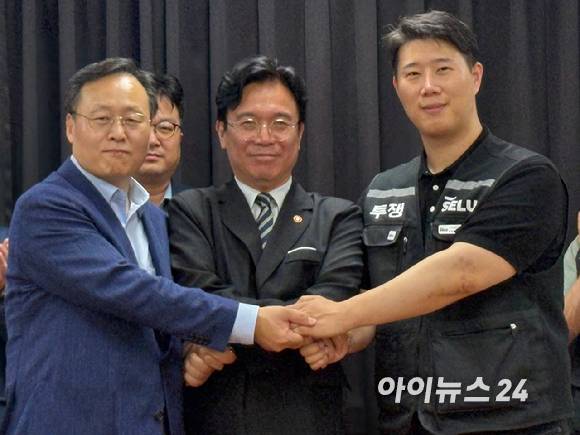 여명구(왼쪽부터) 삼성전자 DS부문 부사장, 김영훈 고용노동부 장관, 최승호 초기업노조 위원장이 지난 20일 수원 경기고용노동청에서 열린 노사 대화를 마치고 손을 맞잡고 있다. [사진=권서아 기자]