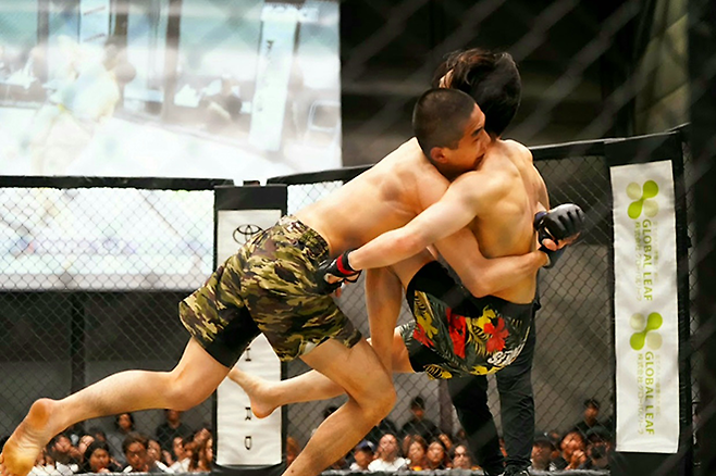 KMMA 플라이급 챔피언 문순수가 2026년 5월 일본 가가와현 다카마쓰 심볼타워전시장 ‘포스 23’ 메인이벤트에서 스트로급 세계랭킹 1위 출신 아키 슈토를 넘어뜨리고 있다. ‘포스’는 슈토 인정 종합격투기 프로 대회다. 사진=뽀빠이연합의원 KMMA 파이터 에이전시 제공