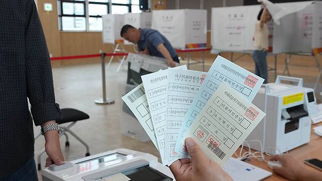 6·3 지방선거 사전투표를 하루 앞둔 28일 광주 서구 농성2동 사전투표소에서 관계자들이 사전투표 모의시험 투표용지를 확인하고 있다./조영권 기자