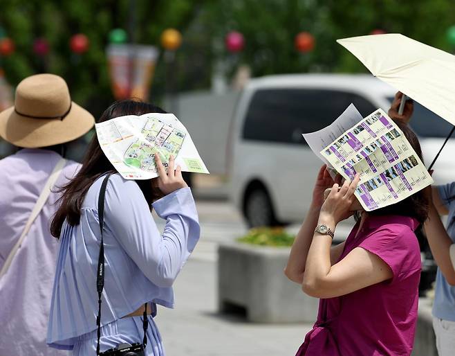 낮 최고기온 30도까지 오르며 초여름 더위를 보인 25일 오후 서울 종로구 경복궁 앞에서 시민들이 종이로 햇빛을 가리고 있다. 2026.05.25. 서울=뉴시스