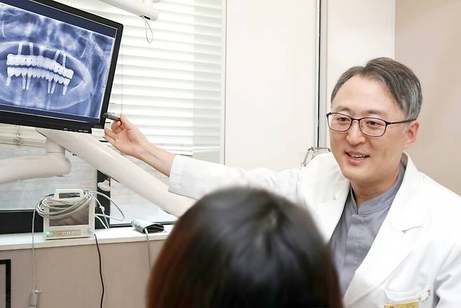 한민우 구강악안면외과 원장이 환자의 치아 상태를 살펴본 뒤 치료 방향을 설명하고 있다. 한민우 원장 제공