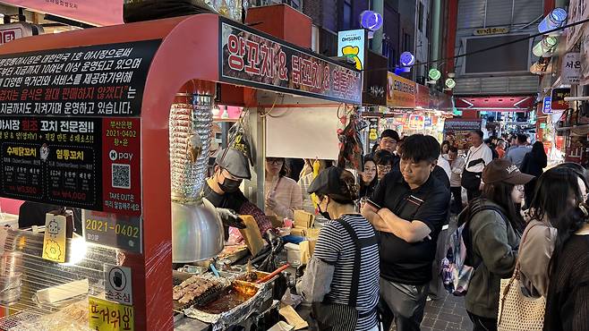 People line up at a stall selling skewers at Kkangtong Market in Jung District, Busan, on May 5. [WOO JI-WON]