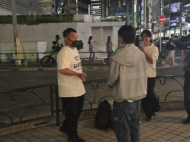 '호메마스 오지상(칭찬 아저씨)'이 일본 도쿄 신주쿠 길거리에서 만난 20대 청년 무리를 칭찬해주고 있다./도쿄=김동현 특파원