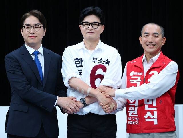 28일 오후 부산 동구 부산 MBC에서 열린 북갑 국회의원 보궐선거 후보자 토론회에서 하정우 더불어민주당(왼쪽부터), 한동훈 무소속, 박민식 국민의힘 후보가 손을 맞잡고 있다. 연합뉴스