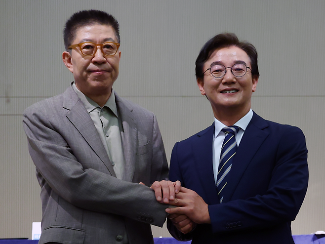 더불어민주당 전재수 부산시장 후보와 국민의힘 박형준 부산시장 후보가 26일 오전 부산 해운대구 동서대학교 센텀캠퍼스에서 열린 관훈클럽·부산일보 주최 관훈토론회에서 손을 맞잡고 있다. [연합뉴스]