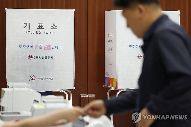 투표소 찾은 유권자 (서울=연합뉴스) 강민지 기자 = 제9회 전국동시지방선거 사전투표 첫날인 29일 서울 서초구의 한 사전투표소에서 유권자가 투표용지를 받고 있다. 2026.5.29 mjkang@yna.co.kr