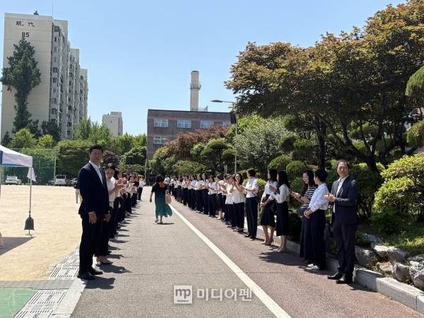 현대건설 관계자들이 총회장을 떠나는 조합원을 향해 박수치고 있다./사진=미디어펜 박소윤 기자