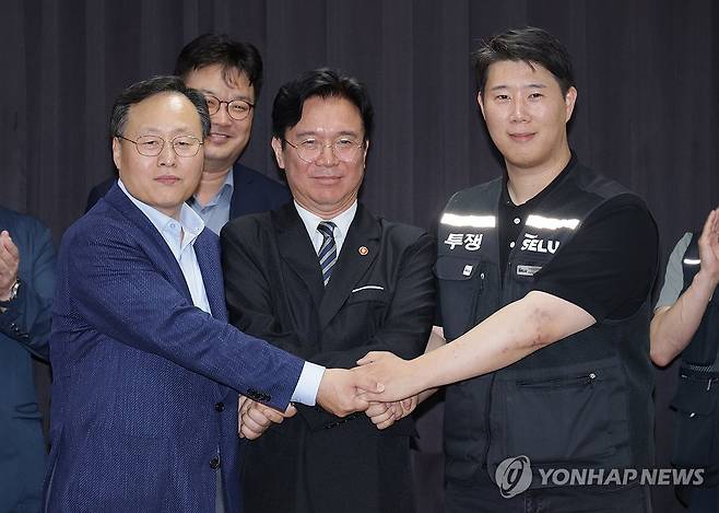손 맞잡은 노사정 (수원=연합뉴스) 홍기원 기자 = 20일 경기도 수원시 장안구 경기고용노동청에서 열린 삼성전자 임금협상을 마친 후 여명구 삼성전자 DS(디바이스솔루션·반도체 사업 담당) 피플팀장과 최승호 삼성그룹 초기업노동조합 삼성전자지부 위원장이 잠정 합의안에 서명한 후 김영훈 고용노동부 장관과 손을 맞잡고 있다. 2026.5.20 [공동취재] xanadu@yna.co.kr