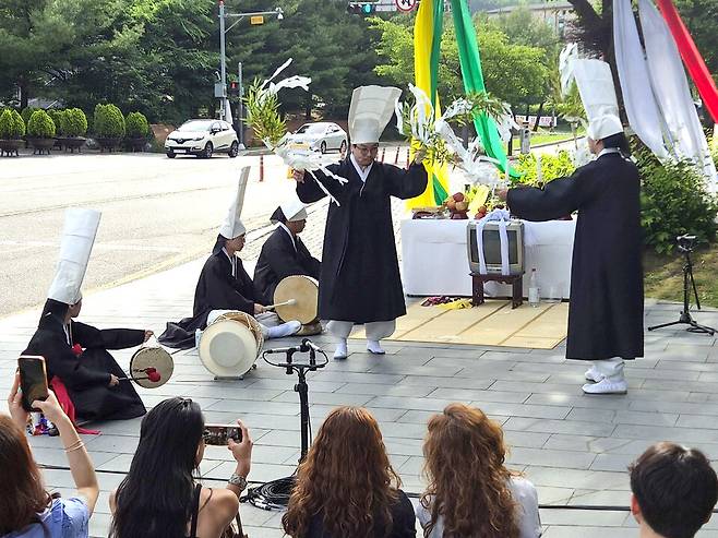 ▲ 1일 오전 8시쯤 백남준아트센터 정문 앞에서 열린 퍼포먼스 '죽음을 모르고 어떻게 삶을 아느냐' 현장 모습. 방지원 동해안별신굿 이수자(오른쪽에서 두번째)와 퍼포머들이 추모 의식을 하고 있다. /박지혜 기자 pjh@incheonilbo.com