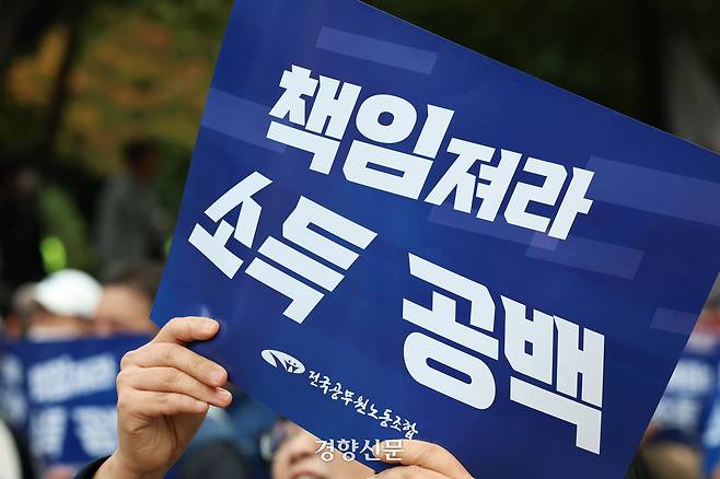 전국공무원노동조합이 지난해 10월21일 서울 여의도 산업은행 인근에서 열린 정치기본권 보장과 소득공백 해소를 촉구하는 총력 투쟁대회에서 손팻말을 들고 있다. 한수빈 기자