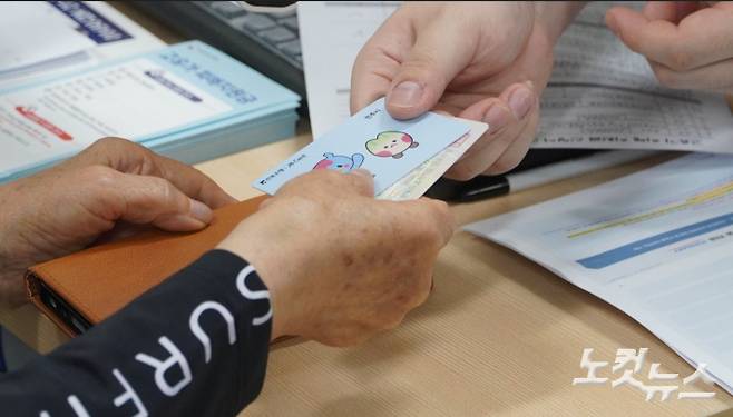 지난달 8일 전주시 서신동 주민센터에서 고유가지원금을 신청한 주민이 선불카드를 받고 있다. 기사와 직접적인 관계 없음. 심동훈 기자