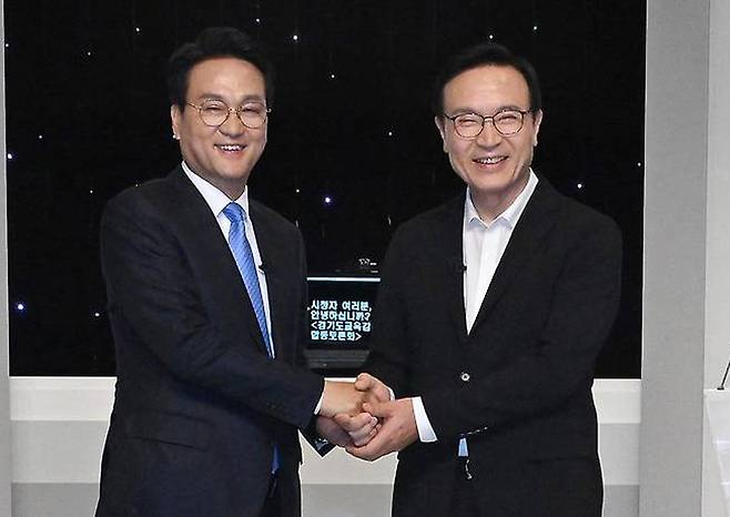 지난달 26일 서울 SBS프리즘타워에서 열린 경기도교육감 후보자 토론회에서 안민석(왼쪽) 후보와 임태희 후보가 두 손을 맞잡고 기념촬영을 하고 있다. 뉴시스