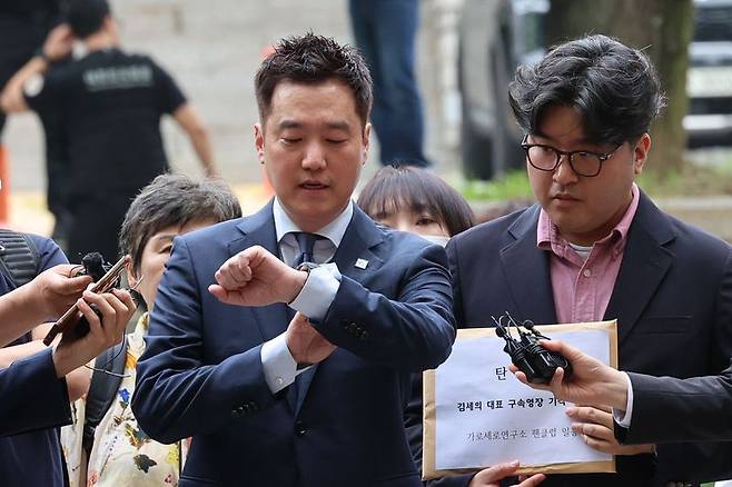 김세의 가로세로연구소 대표가 지난달 26일 서울 서초구 서울중앙지법에서 성폭력범죄의 처벌 등에 관한 특례법 위반(카메라 등 이용 촬영물 반포 등) 혐의로 구속 전 피의자 심문(영장실질심사)에 출석하며 시간을 확인하고 있다. 뉴시스